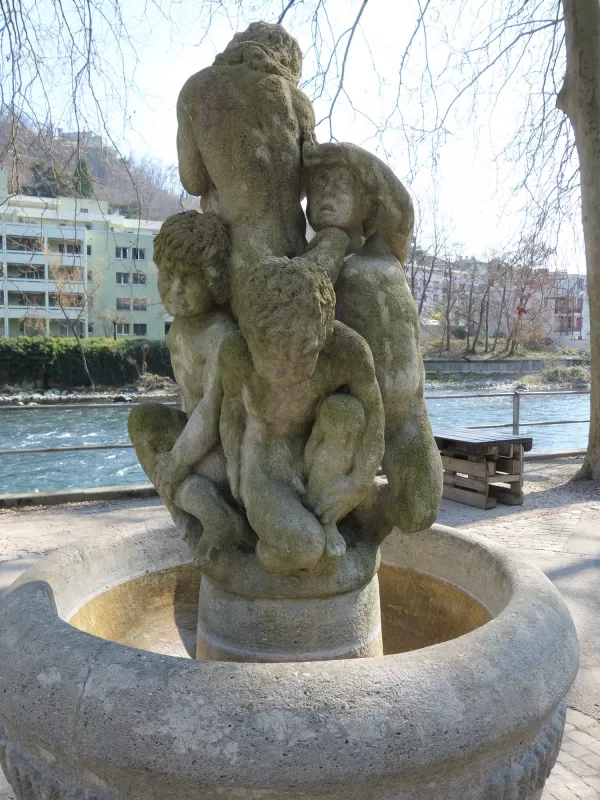 Das Tr&auml;nenbr&uuml;nneli von Hans Trudel an der Limmat: f&uuml;nf weinende Kinder aus Stein &uuml;ber einem runden Becken