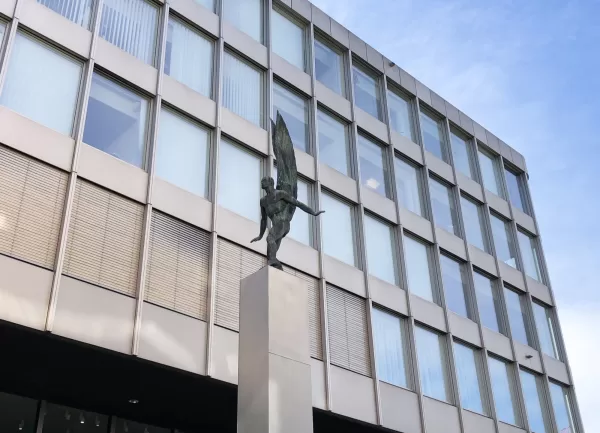 Der Fl&uuml;gelmensch von Hans Trudel, eine Bronzefigur auf hohem Sockel am Bahnhofplatz Baden