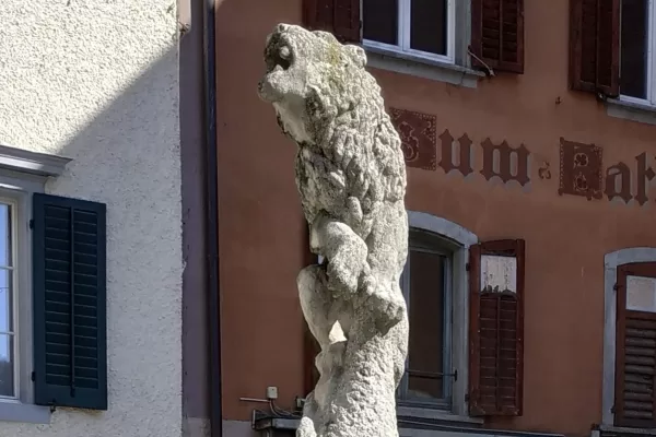 Der steinerne L&ouml;we von Hans Trudel auf dem L&ouml;wenbrunnen in der Badener Altstadt, auf einer S&auml;ule vor einer Altstadtfassade